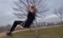 Mädchen auf einer Schaukel mit Baum im Hintergrund, unscharf
